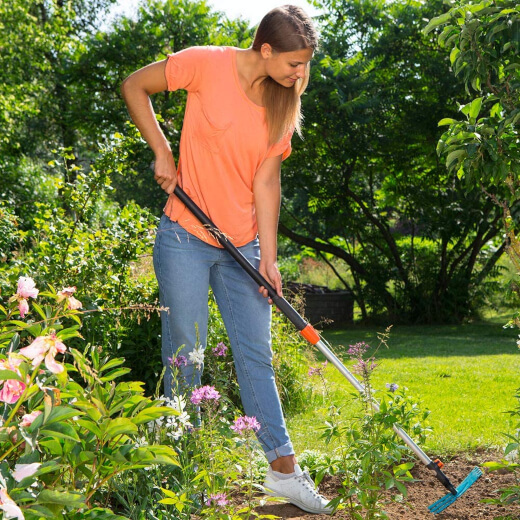 A woman using a garden hoe