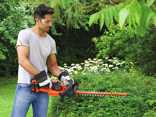 A man using a hedge trimmer A man using a hedge trimmer