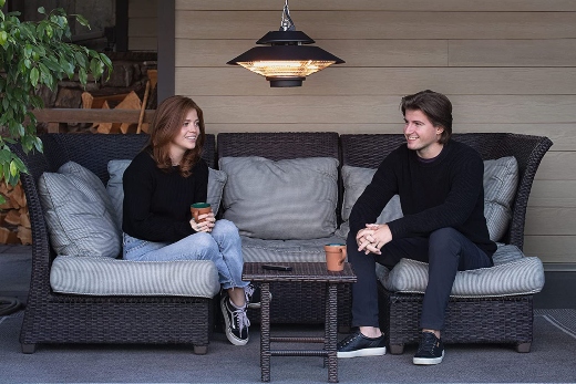 A man and woman using an outdoor electric heater