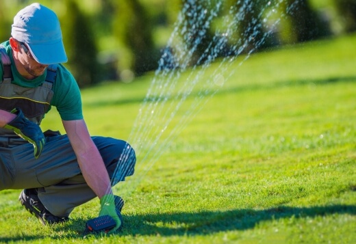 A man installing a lawn sprinkler