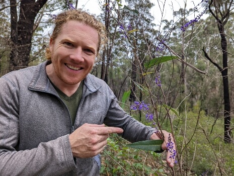 Nathan Schwartz of Aussie Green Thumb with a blooming Hardenbergia
