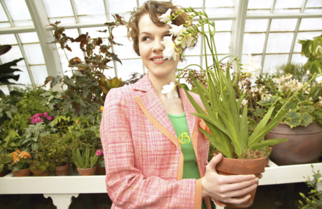 A woman growing a Freesia in a pot