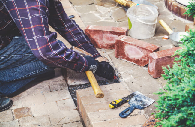 A landscaper using a brick chisel