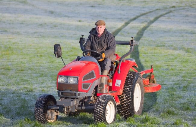 A man using a compact tractor