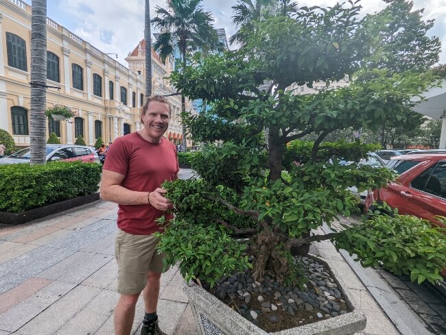 Nathan from Aussie Green Thumb standing beside a stunning bonsai