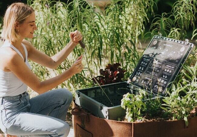 A woman using a subpod compost bin